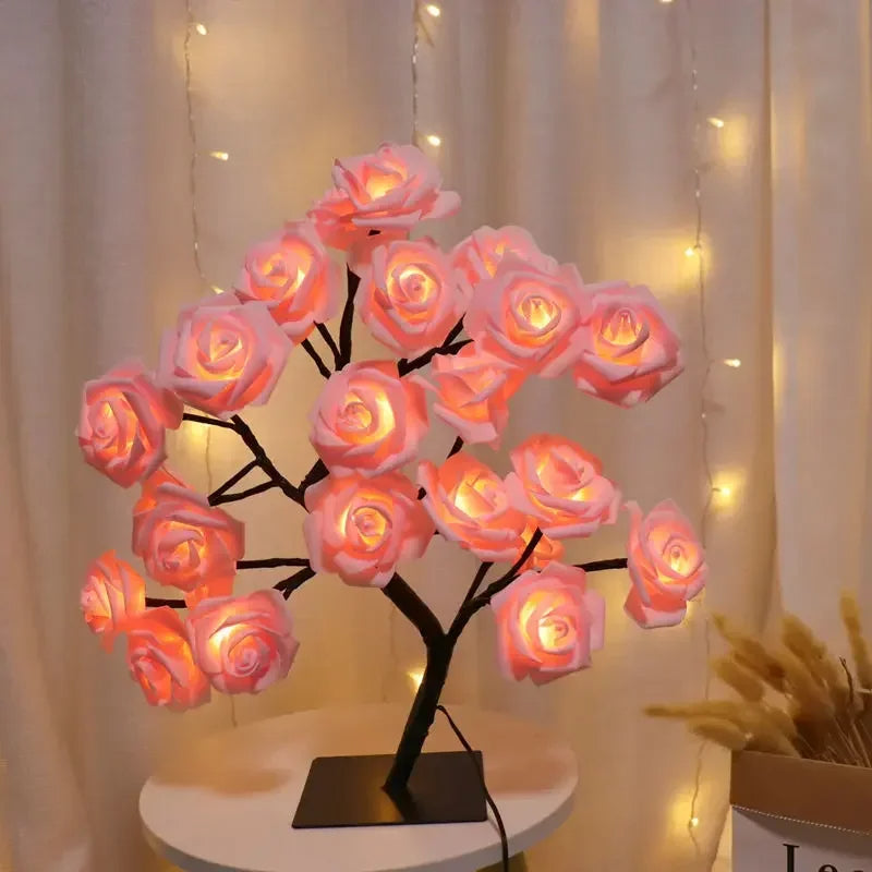 Decorative LED rose flower lamp with warm pink glow, featuring realistic rose-shaped lights on a black tree branch frame, set against a softly lit backdrop for a cozy, romantic ambiance. Ideal for home decor or mood lighting.
