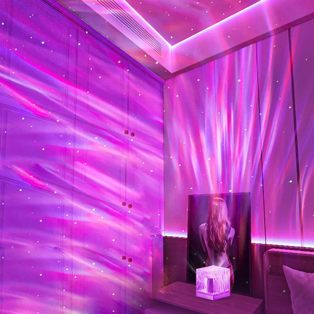 Enchanting pink and purple LED projection lamp illuminating a room with aurora-like patterns and soft, starry lights across the walls and ceiling. Positioned on a nightstand beside an artistic portrait, this lamp enhances the room’s aesthetic with a mystical, atmospheric glow, perfect for creating a cozy and imaginative ambiance.