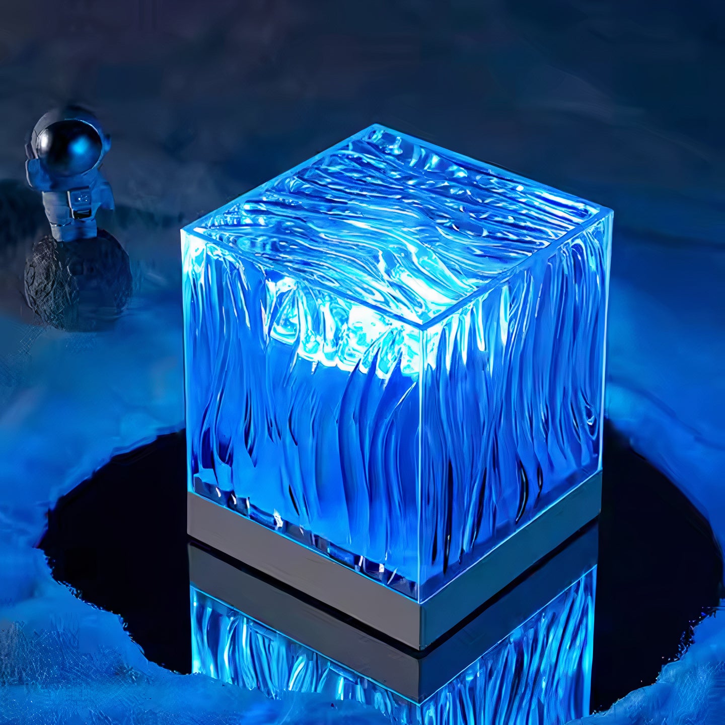 Modern blue LED cube lamp with textured wave design, emitting ambient light on a metallic base, perfect for home decor and mood lighting. Unique astronaut figurine in the background adds space-themed aesthetic, creating a futuristic atmosphere.