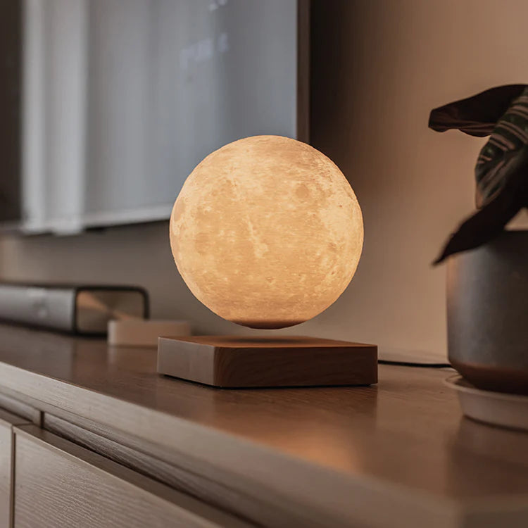 A levitating moon lamp emitting a warm, golden glow, floating above a minimalist wooden base on a sleek console. Positioned in a cozy setting, it adds a soft, ambient light, creating a tranquil atmosphere perfect for relaxation. The realistic lunar surface texture adds a touch of celestial elegance to the room.
