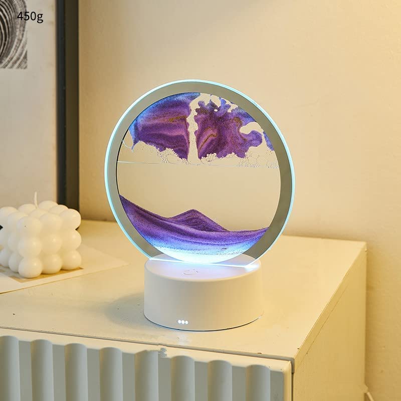 A circular LED sand art lamp displaying purple sand cascading into a mesmerizing mountain landscape. The lamp emits a soft glow, enhancing the tranquil effect, making it perfect for a bedside or desktop decor piece.
