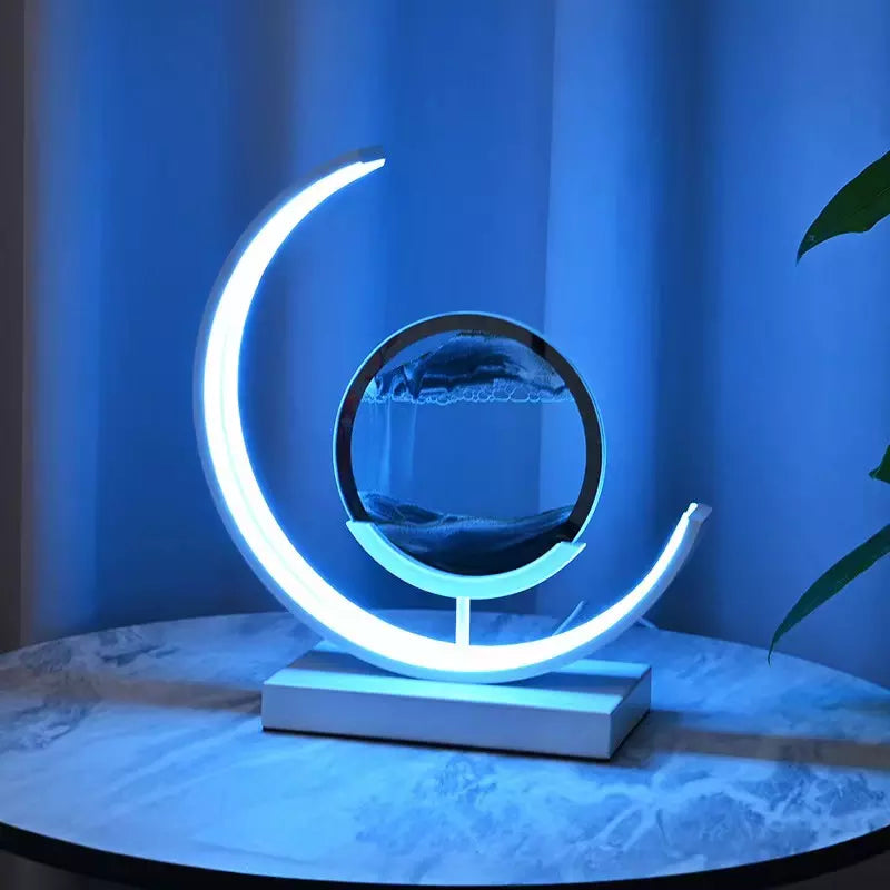 Modern crescent-shaped LED sand art lamp in a calming blue glow, showcasing a dynamic sandscape within a circular frame. Ideal for creating a tranquil ambiance in bedrooms or living spaces.