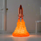 Rocket lamp featuring a realistic space shuttle design with illuminated, fiery orange LED flames, creating a liftoff effect. The unique space-themed decor piece stands out in a dimly lit room, ideal for adding a touch of adventure to a bedroom or workspace. Perfect gift for space enthusiasts and kids, this rocket night light brings creativity and imagination to room decor.